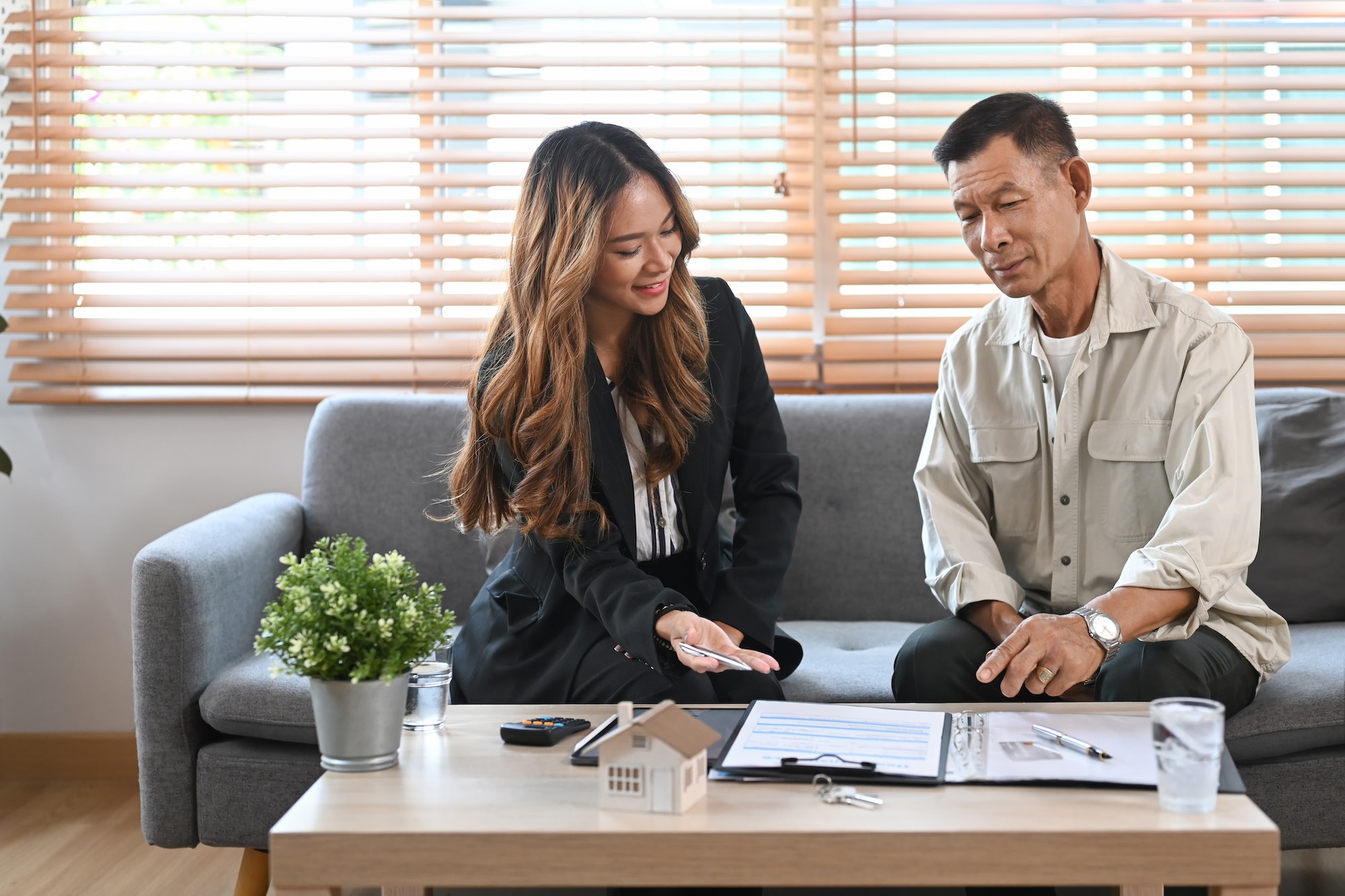 Elderly man discussing property purchase with financial advisor.